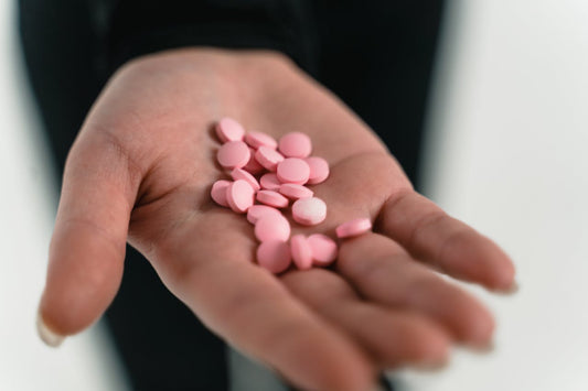Mano che tiene pillole rosa, esempio di pillole per l’erezione senza ricetta comunemente acquistate online.